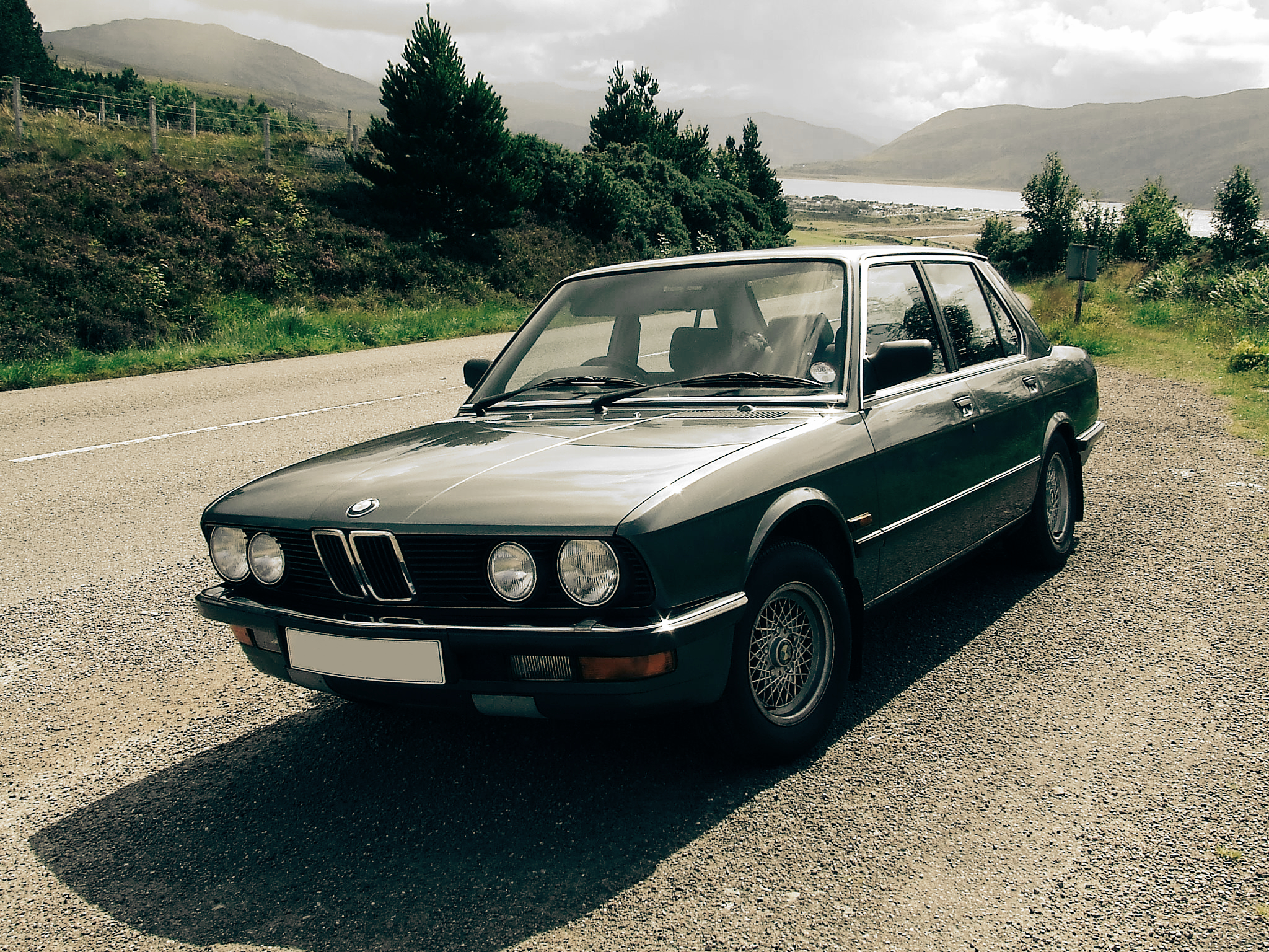 an old black car on a gravel road