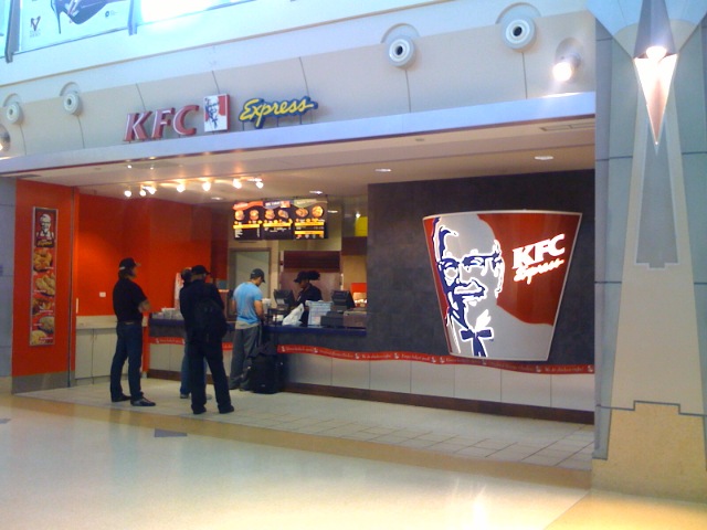 people standing in front of a kfc restaurant