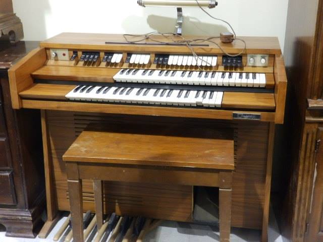 a musical organ in an older antique oak wood cabinet