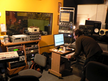 there are two people looking at a computer in a recording studio