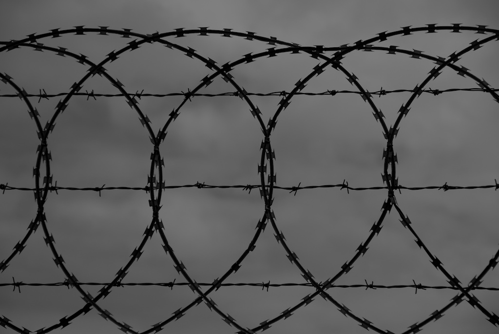 a pair of barbwires are placed against a cloudy sky