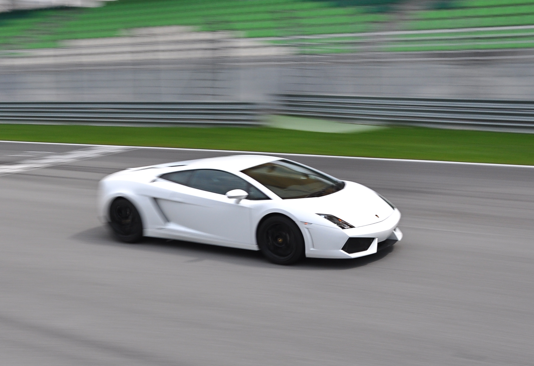 a white sports car driving down the track