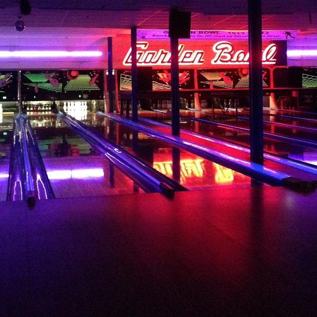 the bowling alley has neon lights and bowling lanes