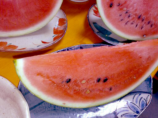 a watermelon slice on a plate that is next to a small bowl
