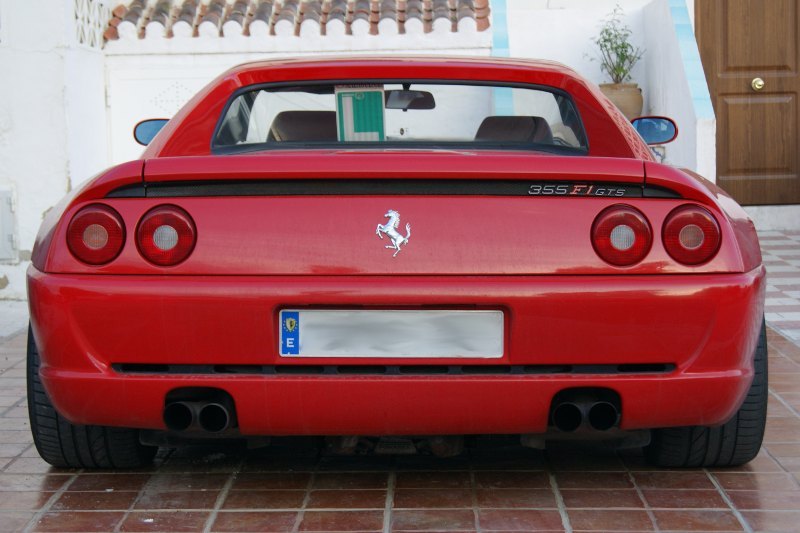 a red sports car with a black stripe on the rear