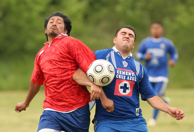 a soccer game where the opposing players are trying to control the ball