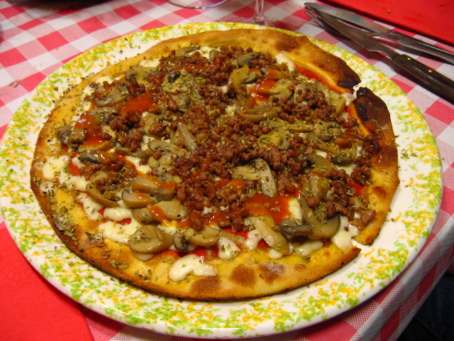 an uncooked pizza sits on a round dish