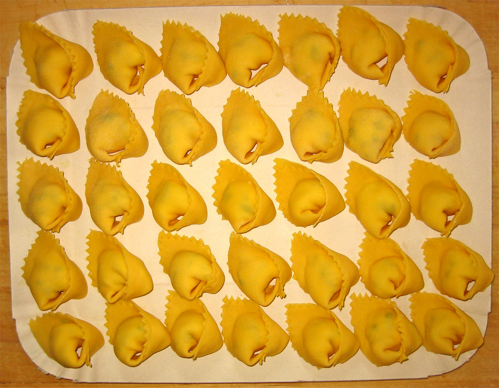 pasta shells are arranged in rows on a  board