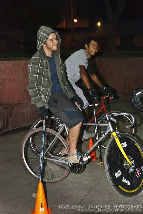 two men riding bikes with helmets on