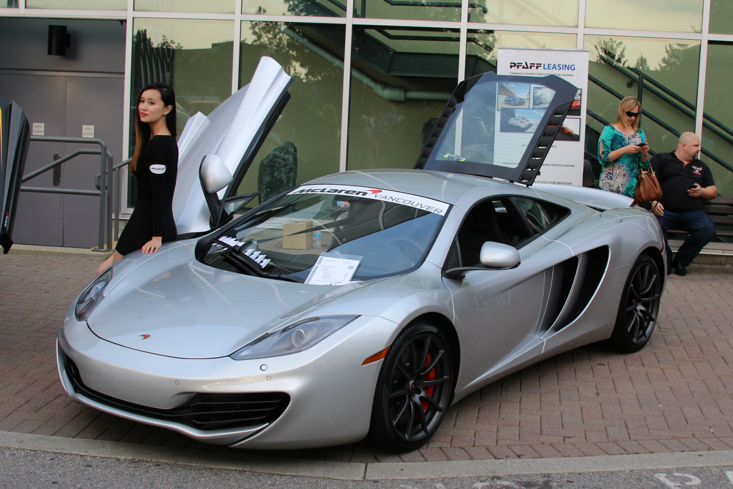 a car with its doors open with people standing outside