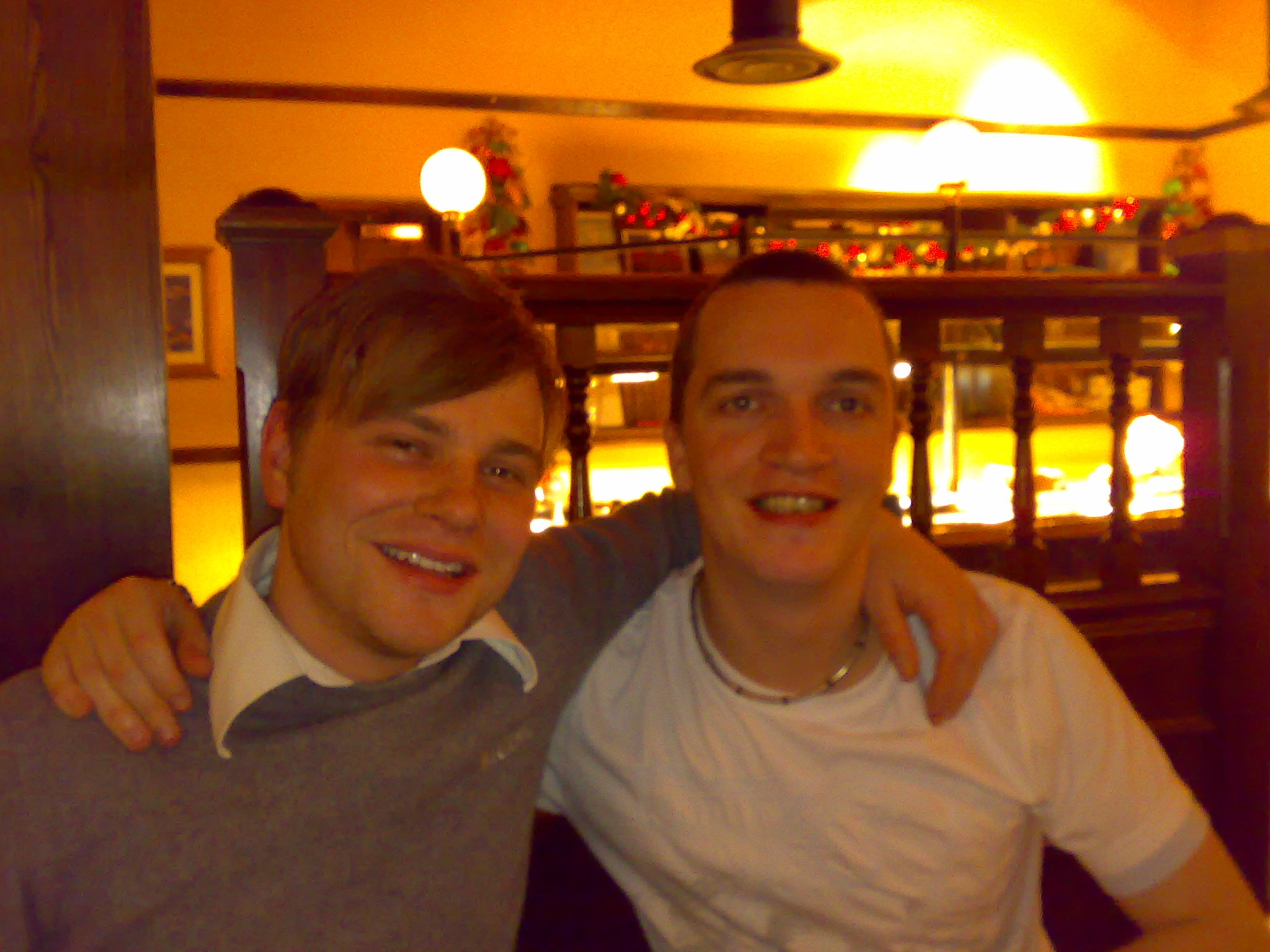 two men are smiling for the camera in a restaurant