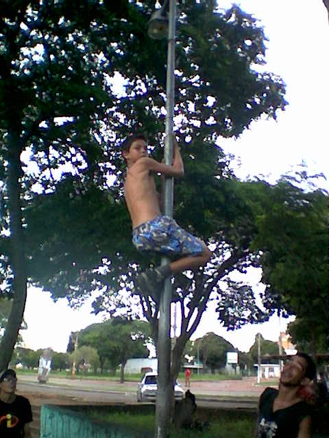 a man hanging upside down on the top of a pole
