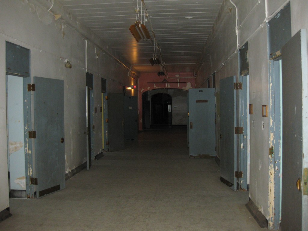 a hallway with two rows of closed doors on both sides