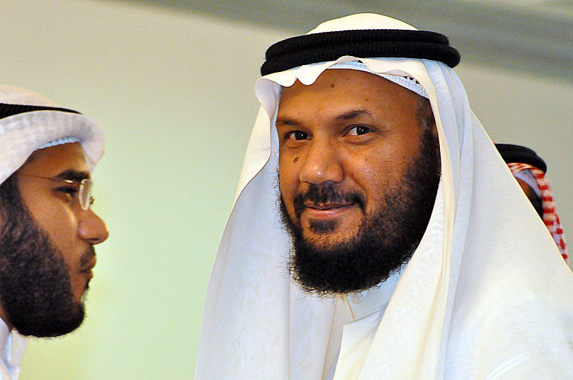 two men in white dresses one is talking and the other has a beard