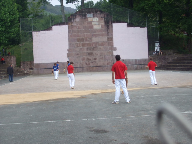 a bunch of boys on some sort of court with baseball equipment
