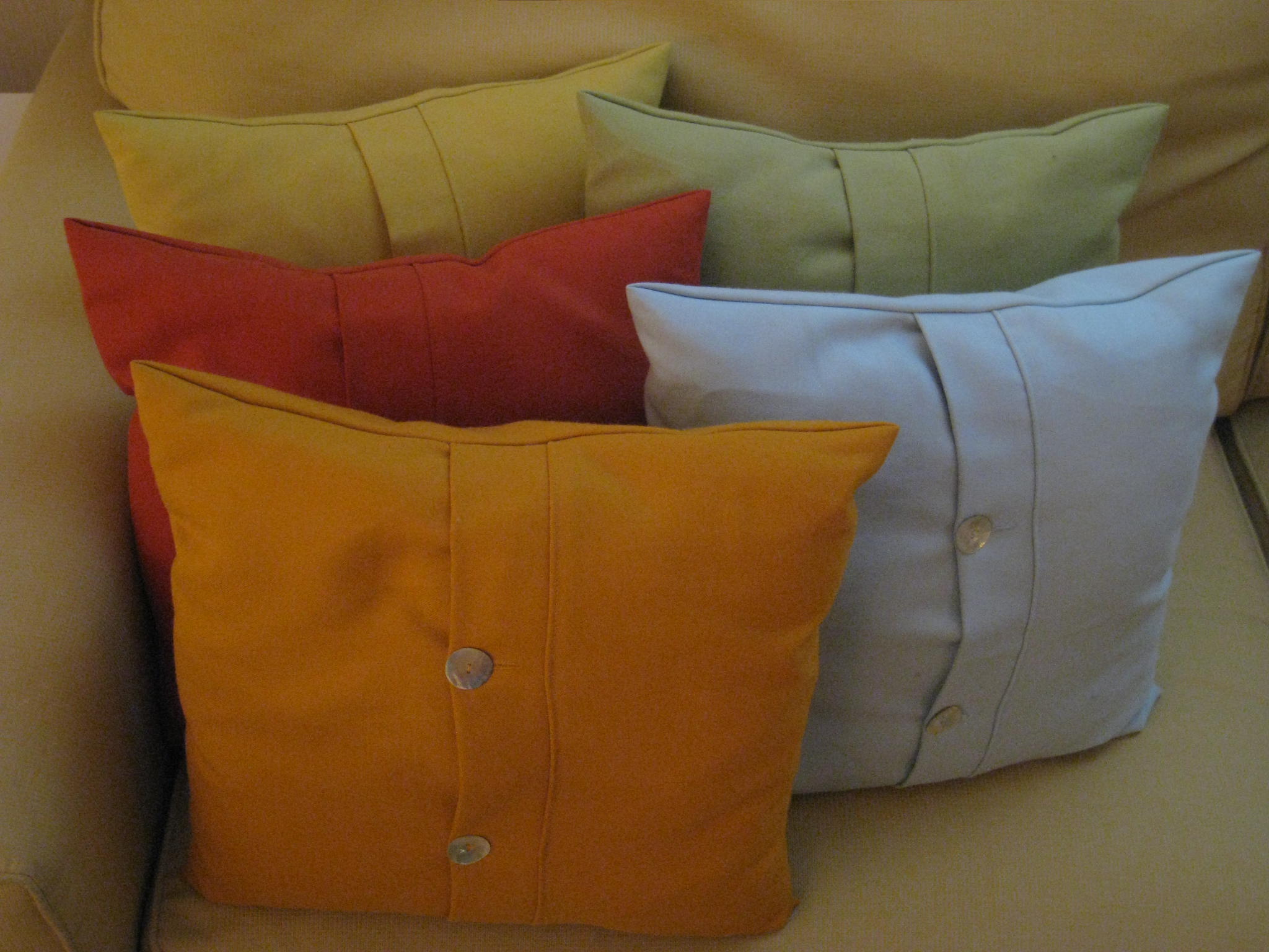 a number of different colored pillows on a couch