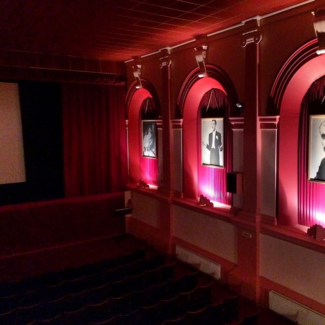 a theater with red light from large windows