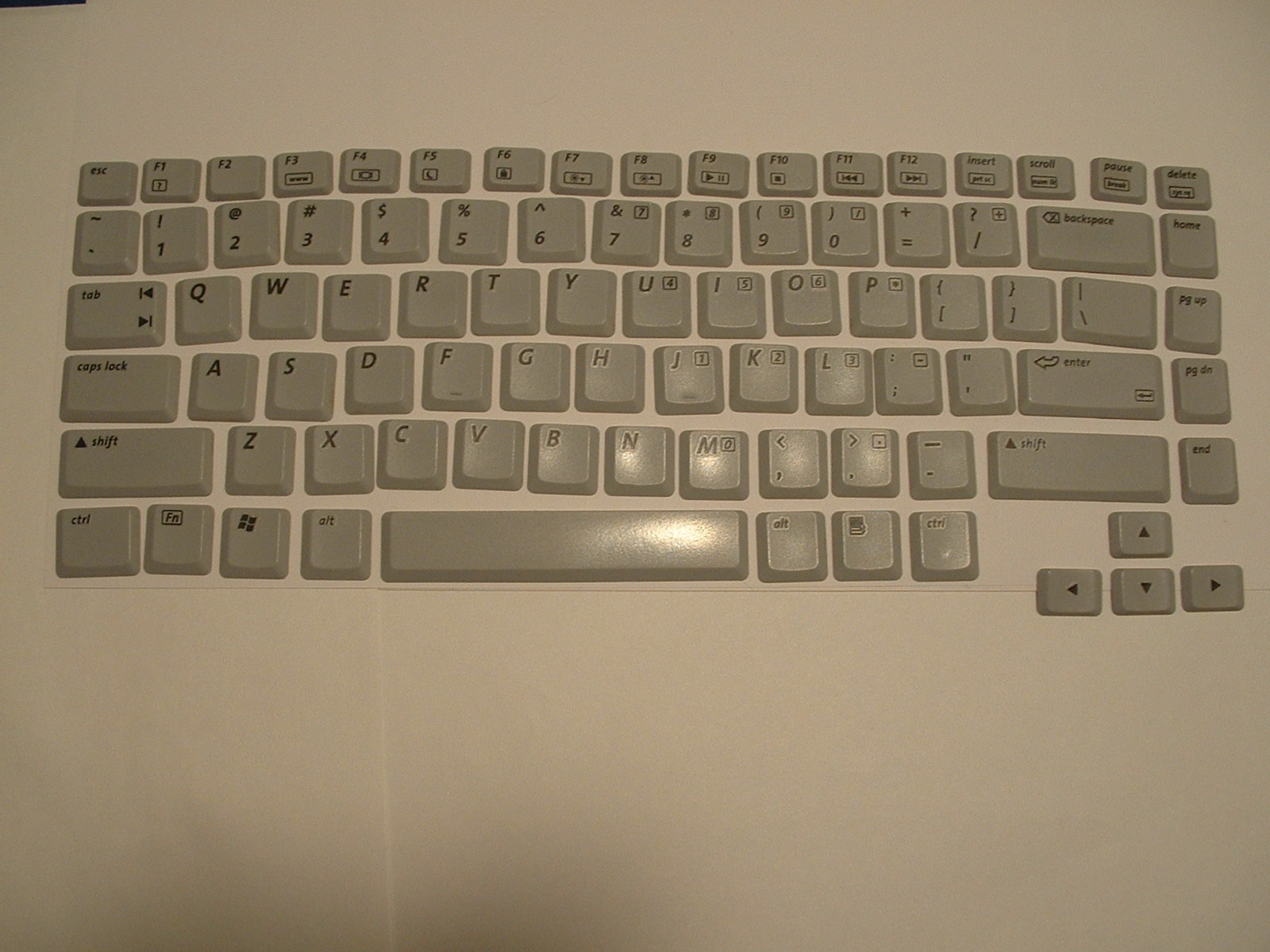 a computer keyboard sitting on top of a white desk