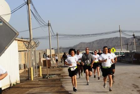 a group of people run down a street in shorts and shirts