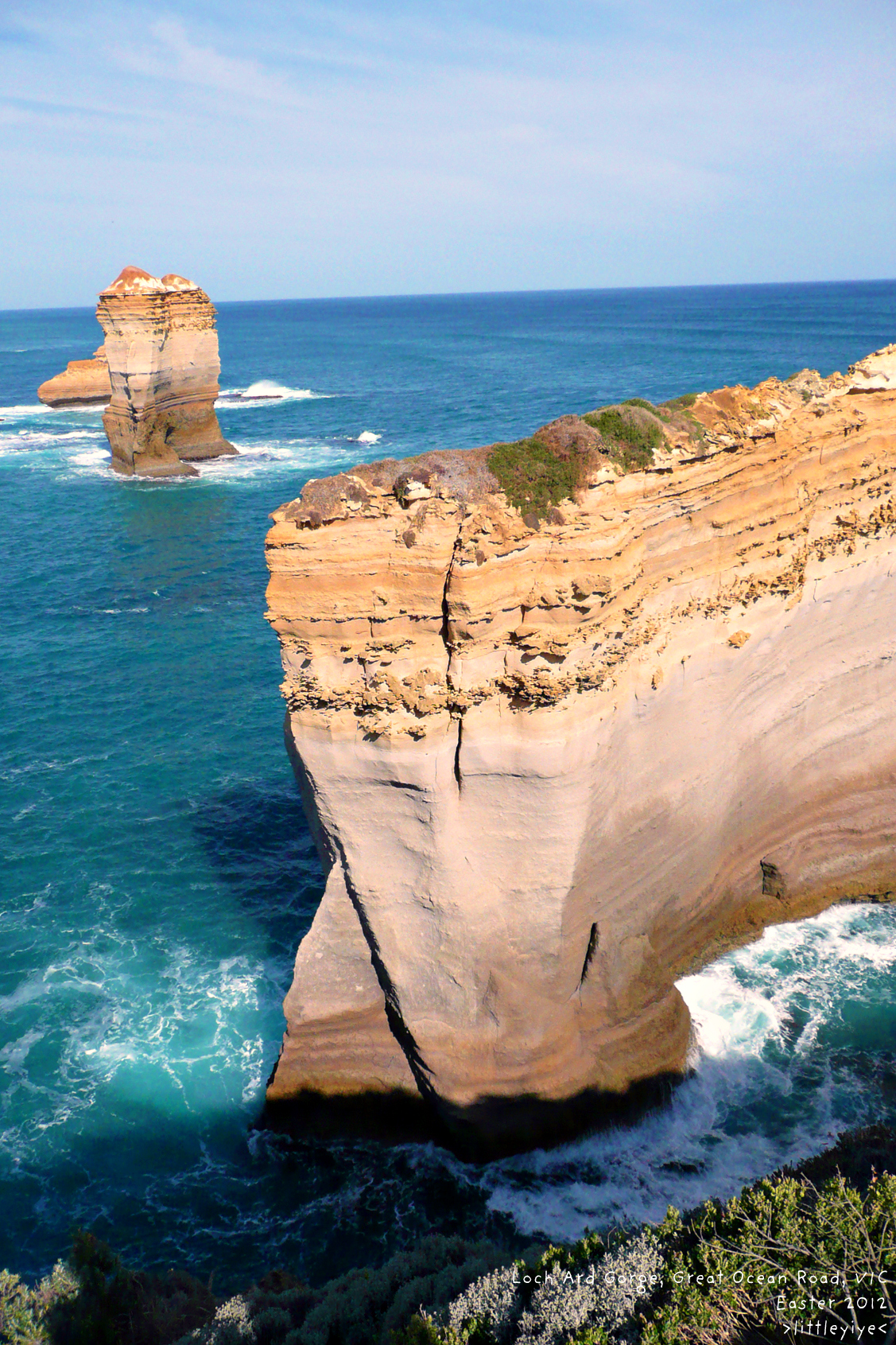 the sea is rolling against the rocky cliff