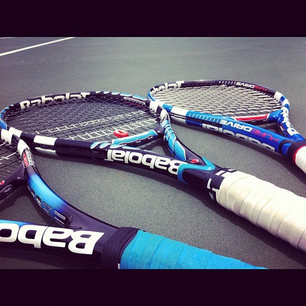 four tennis rackets on a court laying flat