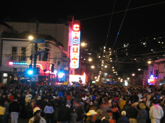 many people are gathered on the street near the theater