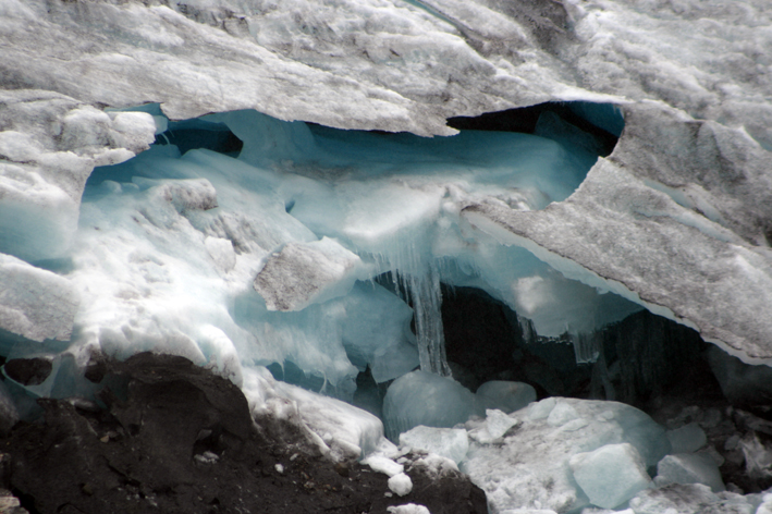 an ice cave with small chunks of snow and icicles