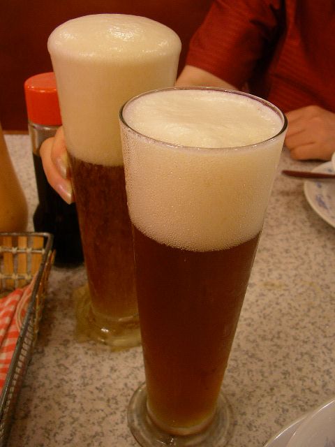 two tall glasses with liquid in them on a table
