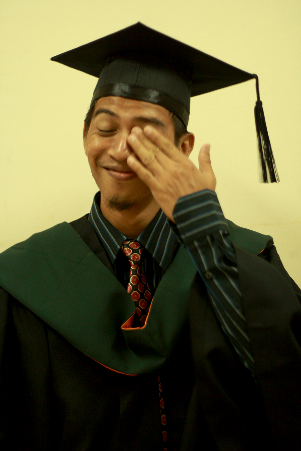 a man in a cap and gown saluting to someone