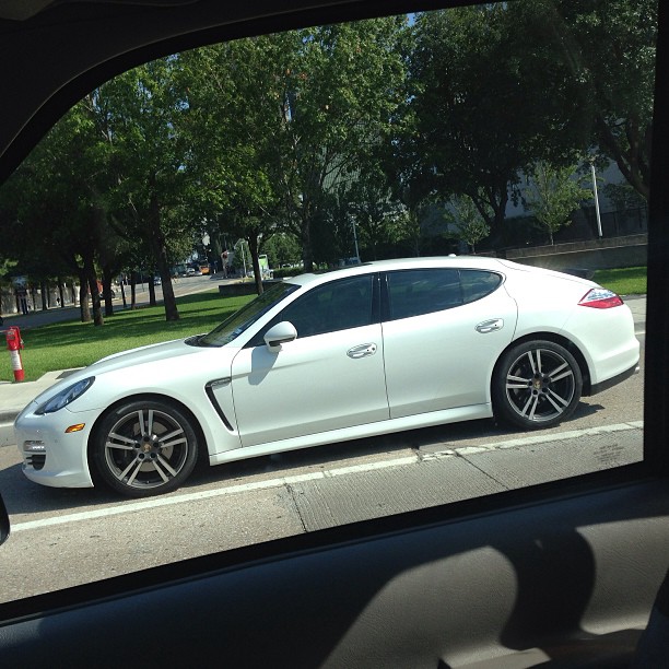 a white car parked on a street next to a sidewalk