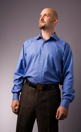 man with bald head, blue shirt and black pants looking up