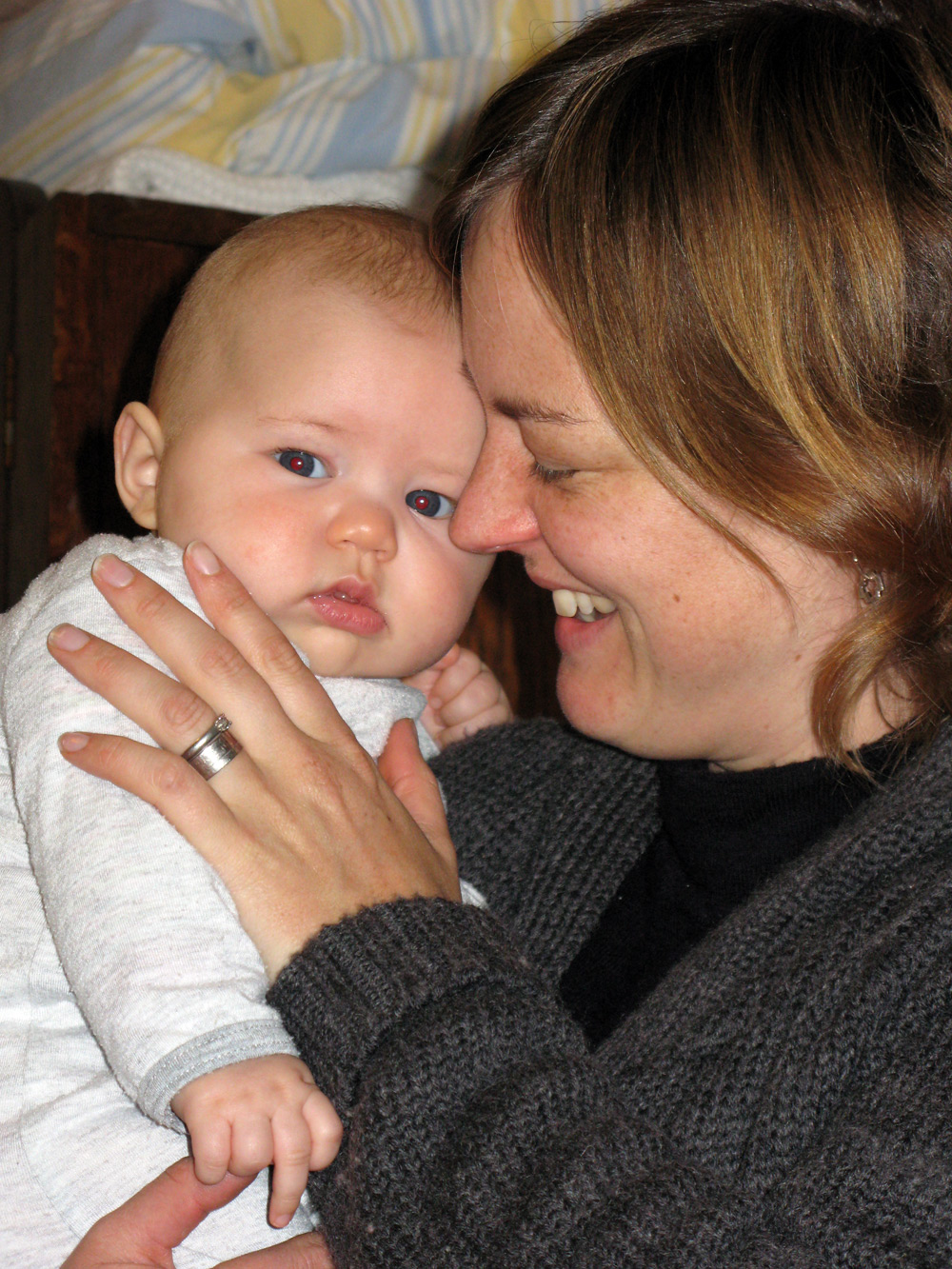 a woman holds her baby while smiling
