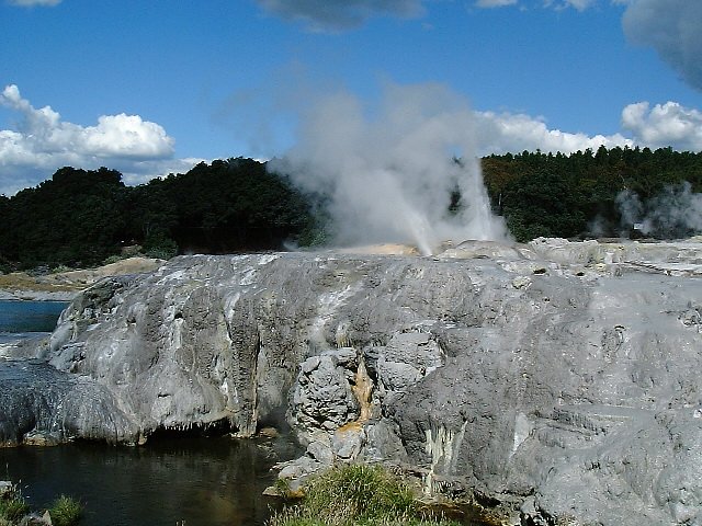 the large and narrow geyser at the edge of a body of water
