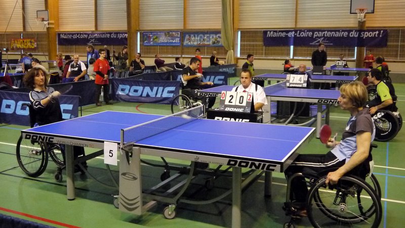 group of people playing table tennis at a gym