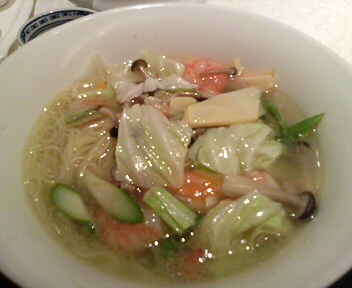 a bowl of soup that includes shrimp and other vegetables