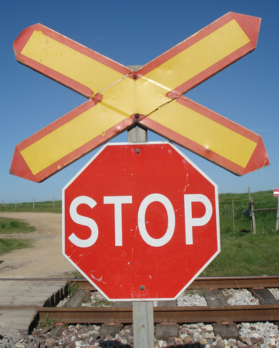 stop sign on railroad track in rural country setting