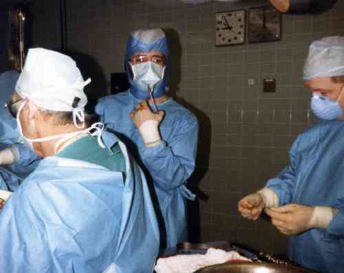a group of doctors are getting ready to perform a operation