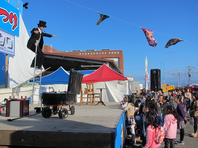 man in top hat with kites above on stage