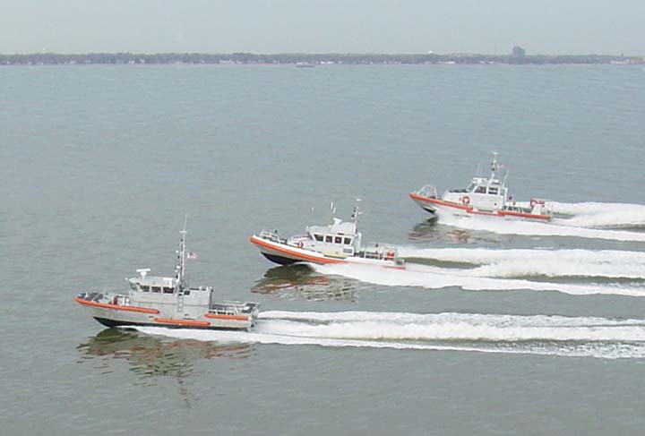 four small boats are riding through the water