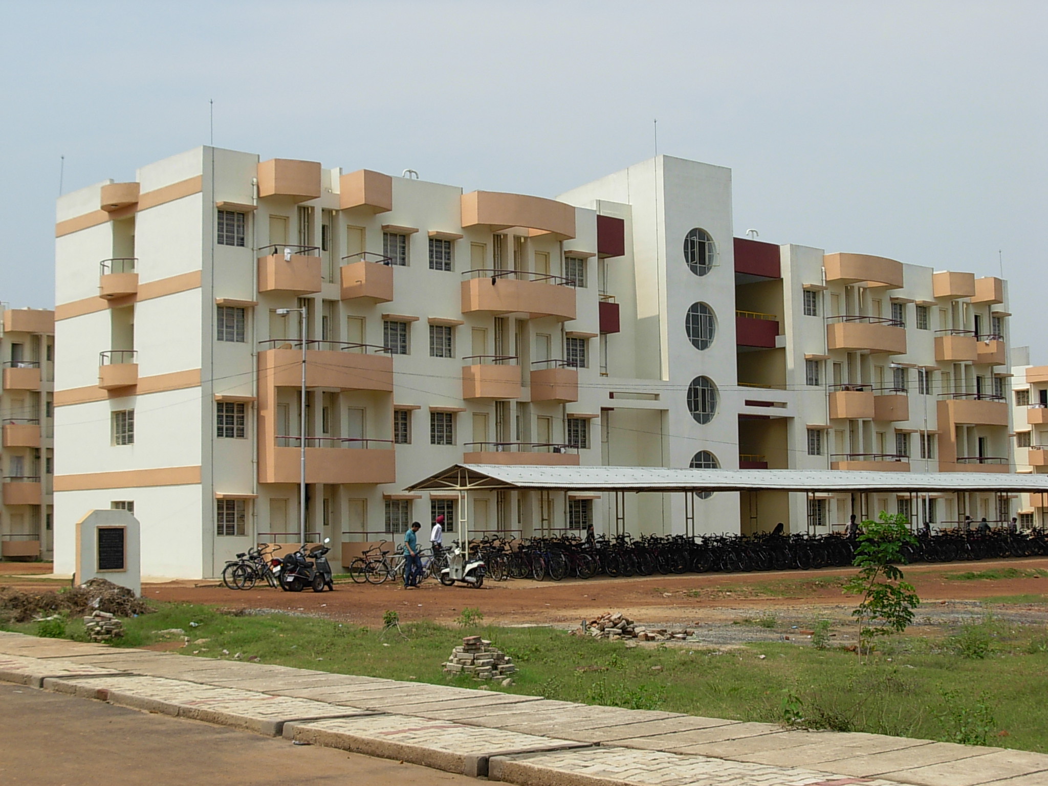 a white building with multiple balconies sits on a street