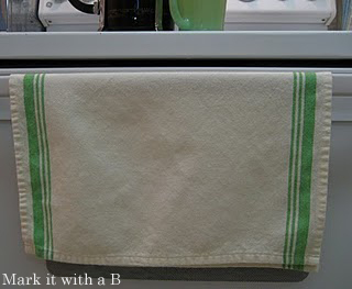 green and white towels hung on the cabinet