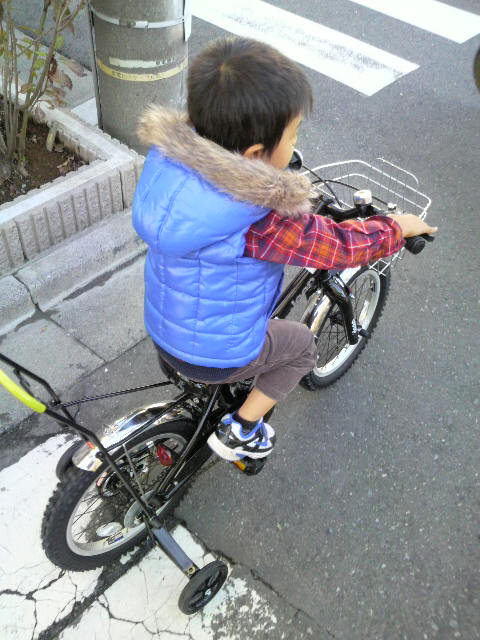 a  riding his bike down the street