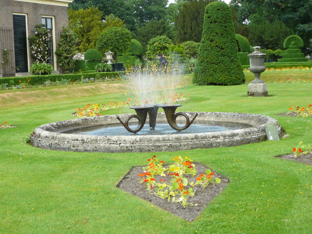 an old fountain with water spouting in a park