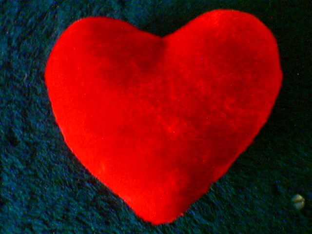 a red heart sitting on top of a blue carpet