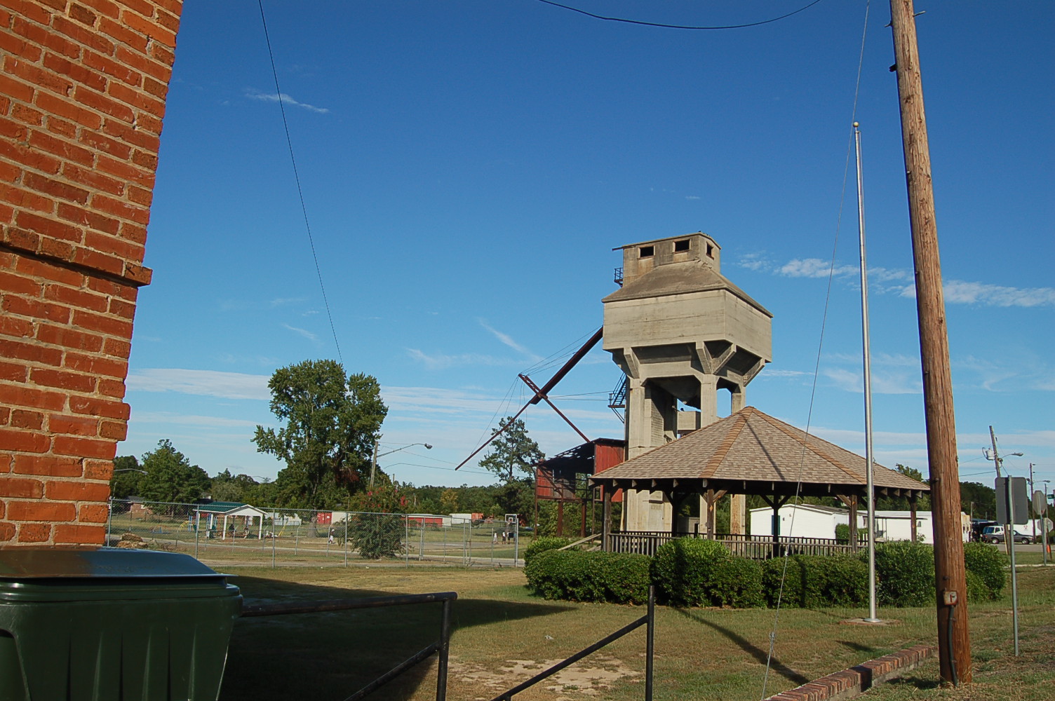 a tower sits behind a fence on a field