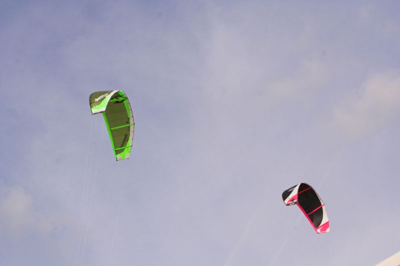 three kites are flying in the blue sky