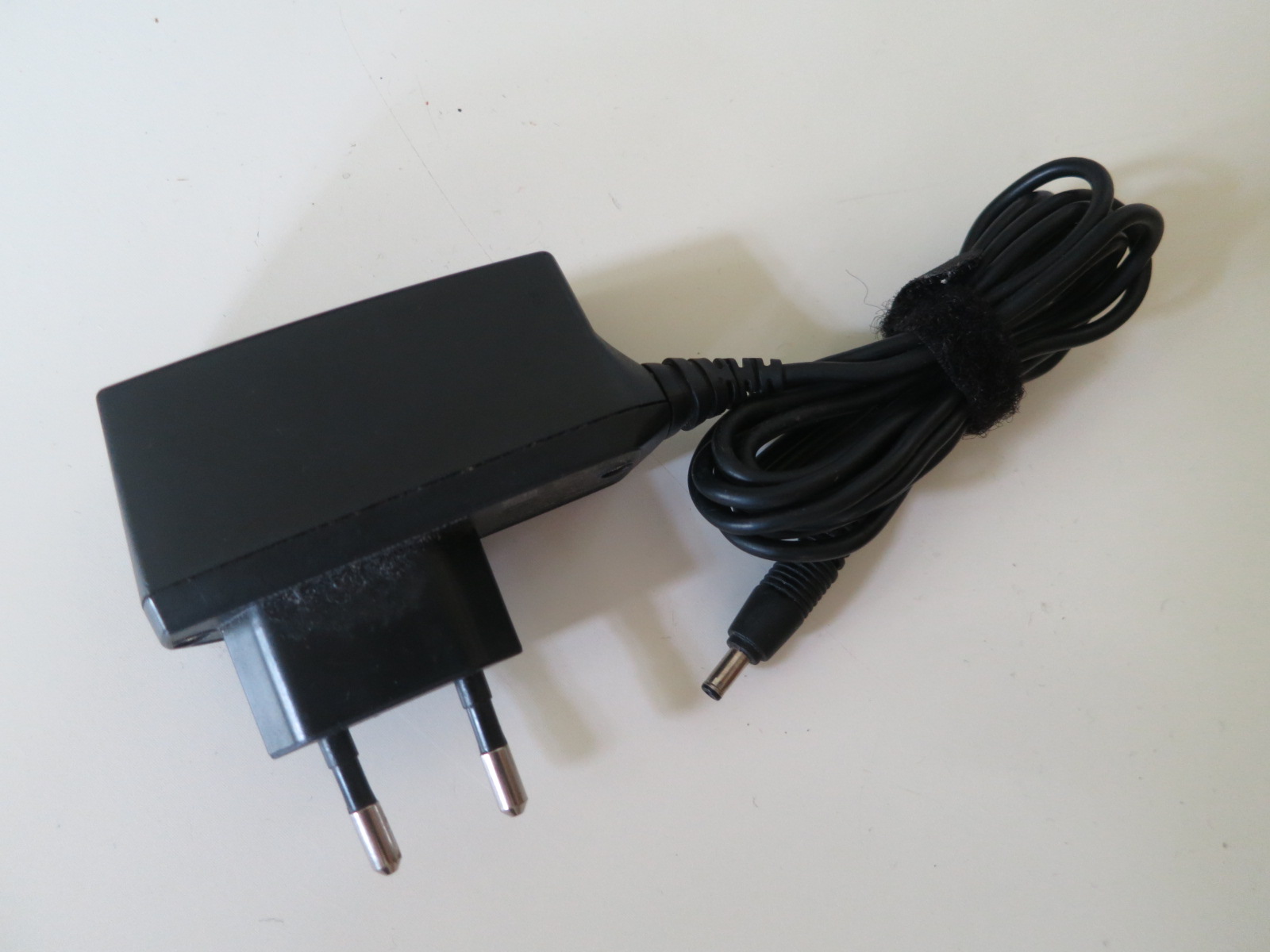 a pair of black electrical cords are plugged into an ac power strip