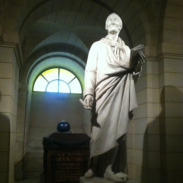 the statue of aham lincoln stands at the entrance of a room with stone walls and arched windows
