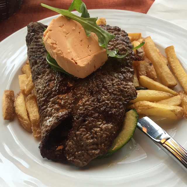 plate with anchovies, french fries and an egg