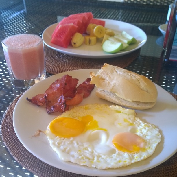 a plate of breakfast food with toast, eggs and watermelon